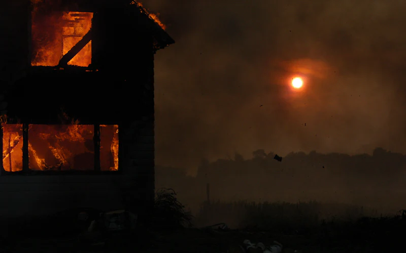 House engulfed in flames at sunset